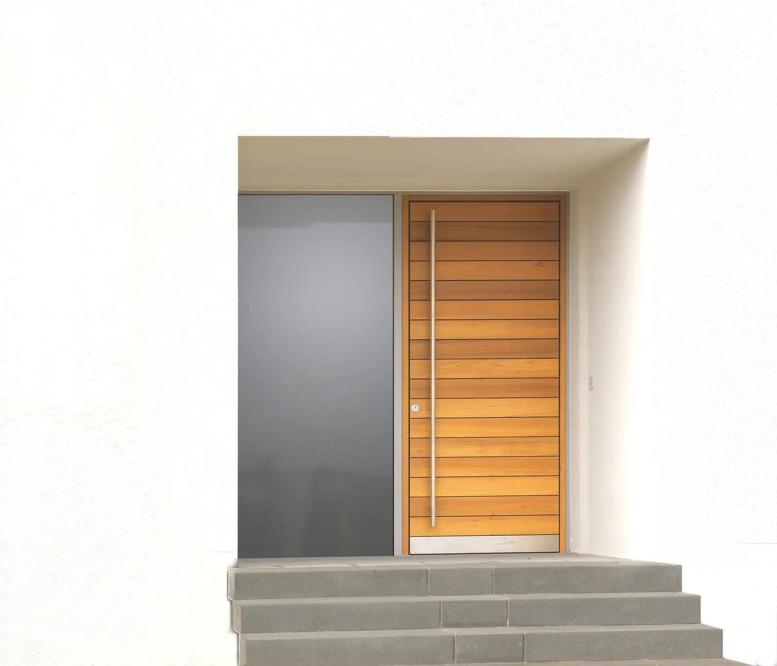 PITHY...moderne Haustür mit horizontalen Eichenholzbrettchen und bodenbündigem Glaselement, elegant im Stahlrahmen integriert.